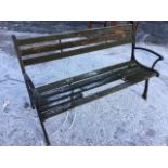 A rectangular garden bench with slatted back and seat, the channelled cast iron ends on sabre legs