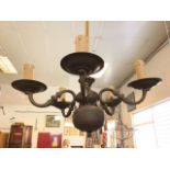 An Edwardian brass chandelier, having cord-bound pipe beneath ceiling rose supporting a Dutch