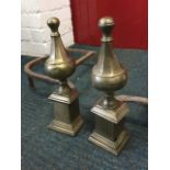 A pair of nineteenth century chenets with octagonal tapering brass finials on moulded column