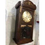 A stained 1940s wallclock with scalloped crest above a glazed door framed by fluted stiles enclosing