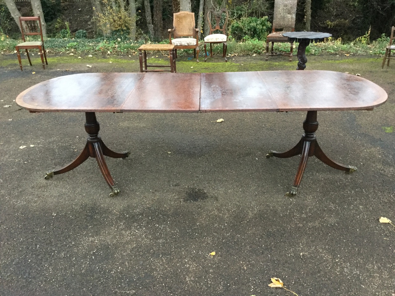 A Georgian style mahogany twin pedestal dining table, the crossbanded top with ebony stringing