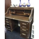 An oak rolltop desk, the tambour enclosing a fitted interior with pigeonholes and small drawers,