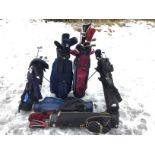 A collection of golf clubs, bags, tees and an electrified golf trolley. (A lot)