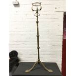 A Victorian art nouveau brass oil lamp stand, with scrolled mounts to cage on telescopic rise-and-