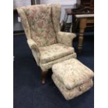 An upholstered wing-back armchair with loose cushion and sprung seat, together with matching