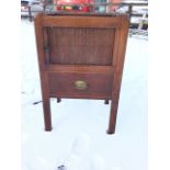 A nineteenth century mahogany bedside stand, the tray top with handles above a tambour fronted