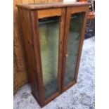 A Victorian pitch pine gun cupboard, the fitted baize lined interior enclosed by chamfered glazed