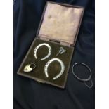 A cased pair of cased hallmarked silver horseshoe napkin rings - Sheffield, 1949, 59g; a childs