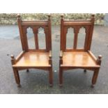 A pair of Victorian oak side chairs, the panelled backs with twin gothic carved apertures beneath