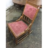 A Victorian mahogany rocking chair, with pink damask studded upholstered seat and back in ribbed