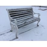 A Victorian style garden bench with slatted back & seat, the arms with lionhead terminals on pierced
