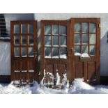 Three glazed hardwood doors, each with nine panes and fielded panels, all mounted with brass 5-lever