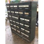 A metal cabinet containing thirty labelled small drawers, with open compartment below. (35.25in x