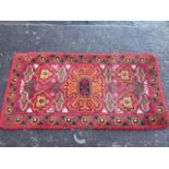 A hand-knotted wool fireside rug with floral medallions on pink field framed by a border of