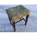 A rectangular mahogany stool with floral needlework seat raised on square tapering legs joined by