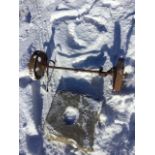 A pair of 10in cast iron wheels on an axel; and a square stone slab with central circular