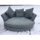 A contemporary crescent shaped daybed sofa with rounded back and loose cushions, raised on square