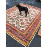 A Turkish carpet woven with central ivory floral field in linked grid, framed by red border of