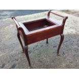 An Edwardian mahogany piano stool, the lifting box seat lacking upholstery, flanked by turned