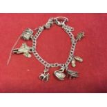 A silver charm bracelet mounted with nine novelties including a rocking horse, a box with hinged