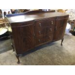 A mahogany sideboard having shaped upstand above rectangular moulded top with three central drawers,