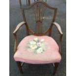 A nineteenth century Hepplewhite style mahogany open armchair, the shield shaped back with pierced