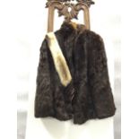 A lined mink fur coat with hook and eye fastenings, pockets, wide collar - size 12/14; and a fox fur