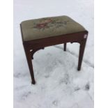 A rectangular Georgian style mahogany stool, the floral needlework drop-in upholstered seat in