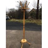 A beech hallstand with fourteen pegs on turned column, the platform base on angled truncheon-