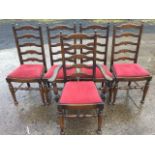 A set of five ladderback dining chairs with one carver, the upholstered seats on skittle legs joined