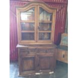 A pine dresser with arched moulded cornice above glazed doors enclosing shelves, the base with two