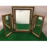 A gilt triptych dressing table mirror with leaf and bead moulding to frames, the central mirror with