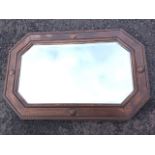 A George VI oak framed mirror with bead and roundel decoration to rectangular octagonal moulded