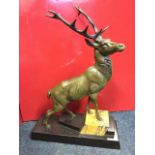 A C20th bronze stag, the beast standing on polished slate & marble stepped plinth. (15.5in x 5in x