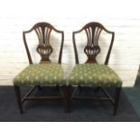 A pair of mahogany dining chairs, the arched back rails above pierced splats with Prince of Wales