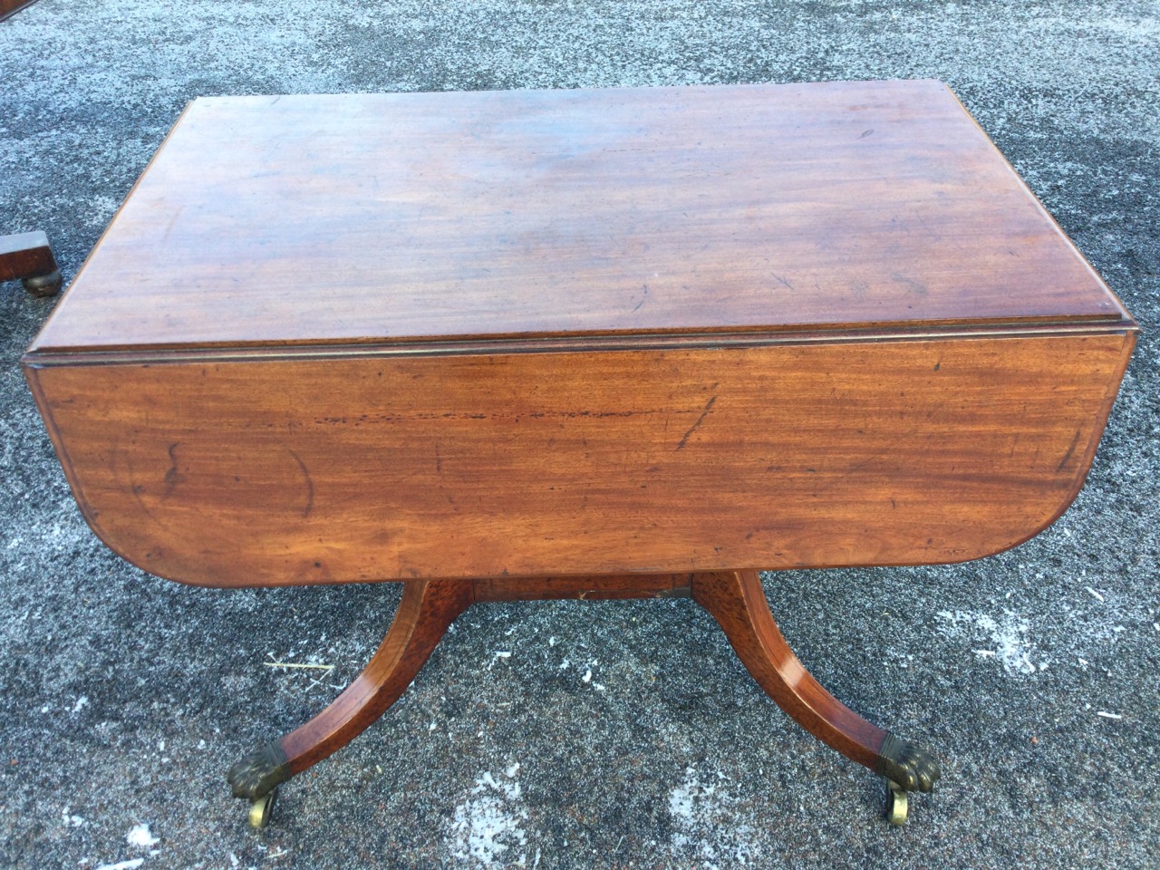 A nineteenth century mahogany sofa table, the rectangular moulded top with D-shaped drop leaves