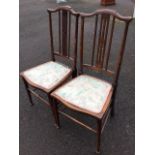 A pair of art nouveau inlaid mahogany bedroom chairs, with crook shaped back rails above spindles