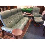 A Stressless three-seater leather upholstered sofa with matching armchair & footstool, with panelled