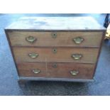 A Georgian mahogany chest of three long cockbeaded drawers mounted with brass plate handles and