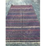 A large Balouch kelim woven with blue, red, cream and orange bands on chocolate brown ground, see