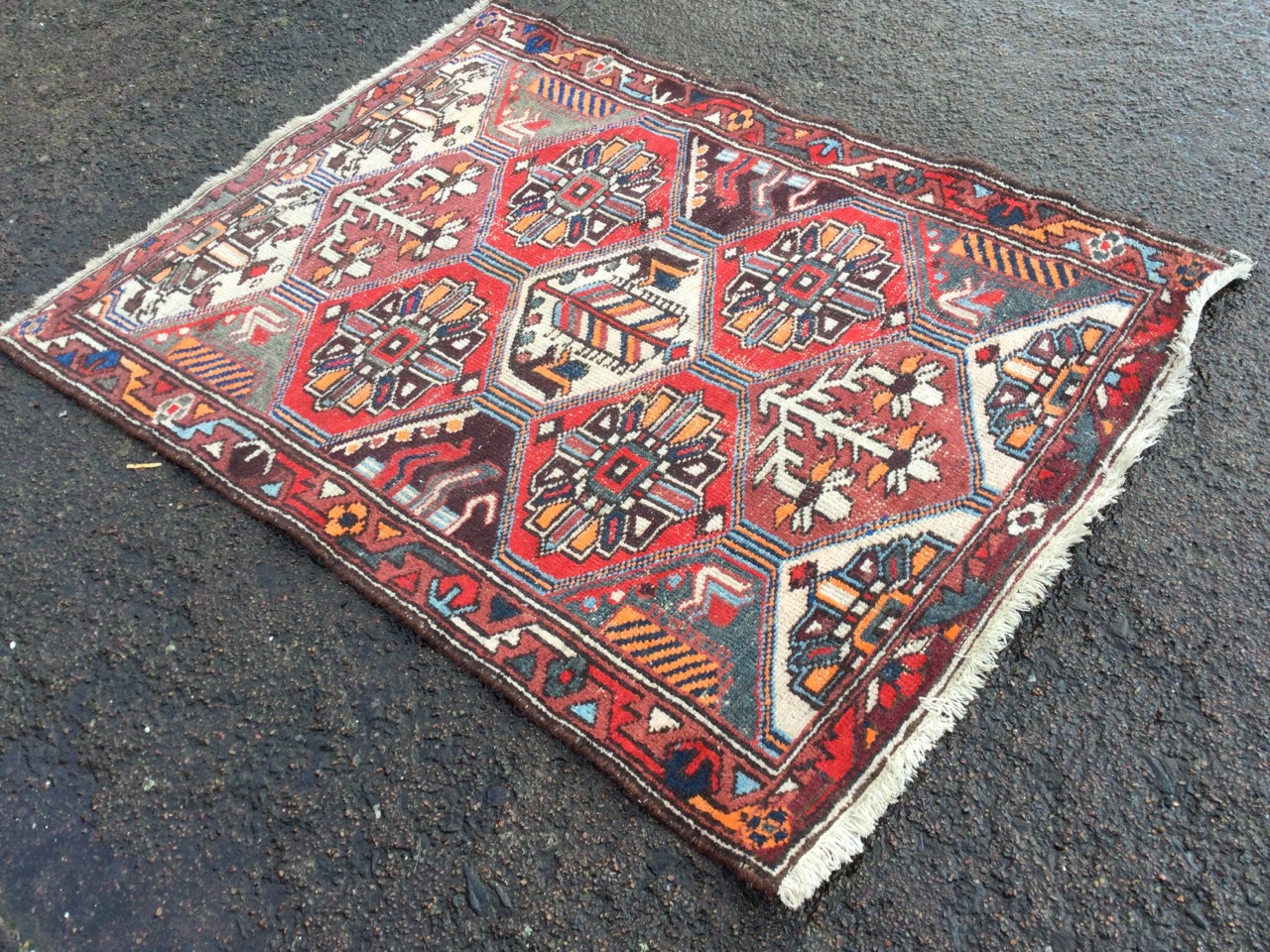 A Turkish rug woven with grid of hexagonal floral panels framed by a border of serrated linked