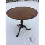 A tip-up top Georgian style oak wine table, the circular tray top on an acanthus carved fluted