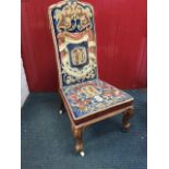 A Victorian rosewood nursing chair upholstered in scrolled needlework with trompe d'oeul style