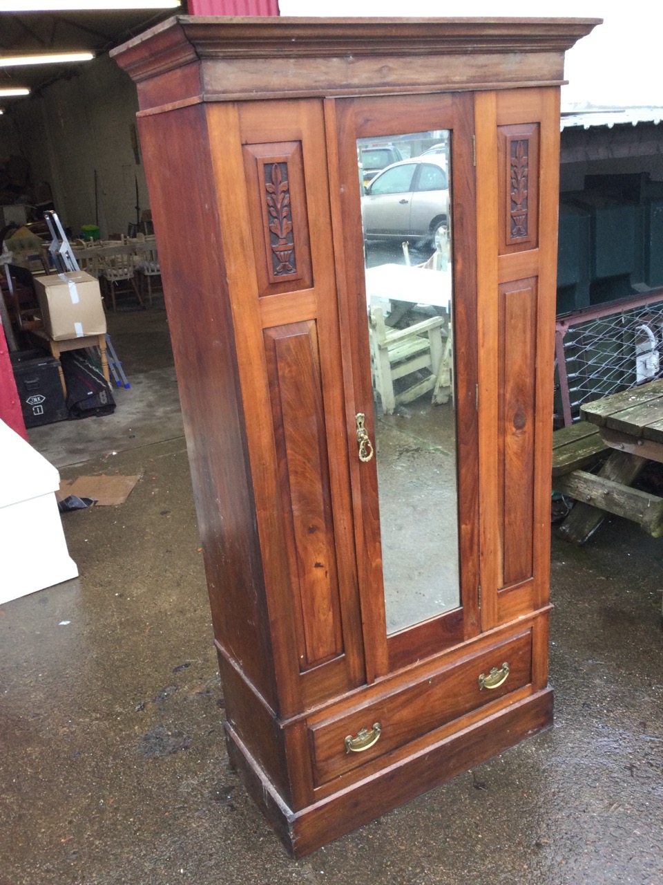 A Victorian walnut wardrobe with moulded cornice above a central bevelled mirror door flanked by