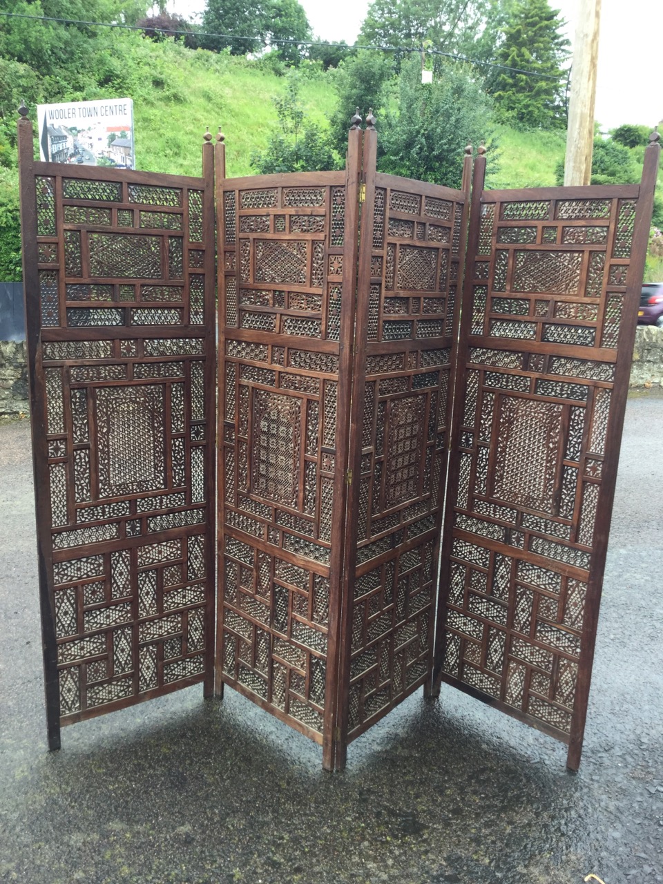 A four-fold oriental carved hardwood screen, with pierced fretwork panels in frames inlaid with