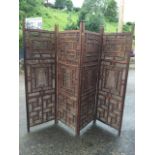 A four-fold oriental carved hardwood screen, with pierced fretwork panels in frames inlaid with