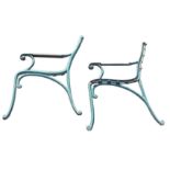 A pair of cast iron bench ends, the moulded arms with wood rests, on scrolled supports and legs. (