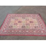 An Egyptian rug woven with field of thirty five rectangular floral panels, within a red border of