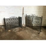 A wrought iron firescreen with scrolled decoration to rectangular gauze panel with hinged wings;