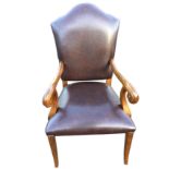 A leather upholstered Queen Anne style armchair, having arched back above scroll carved arms, the
